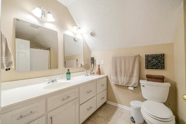 a bathroom with a toilet sink double vanity and mirror