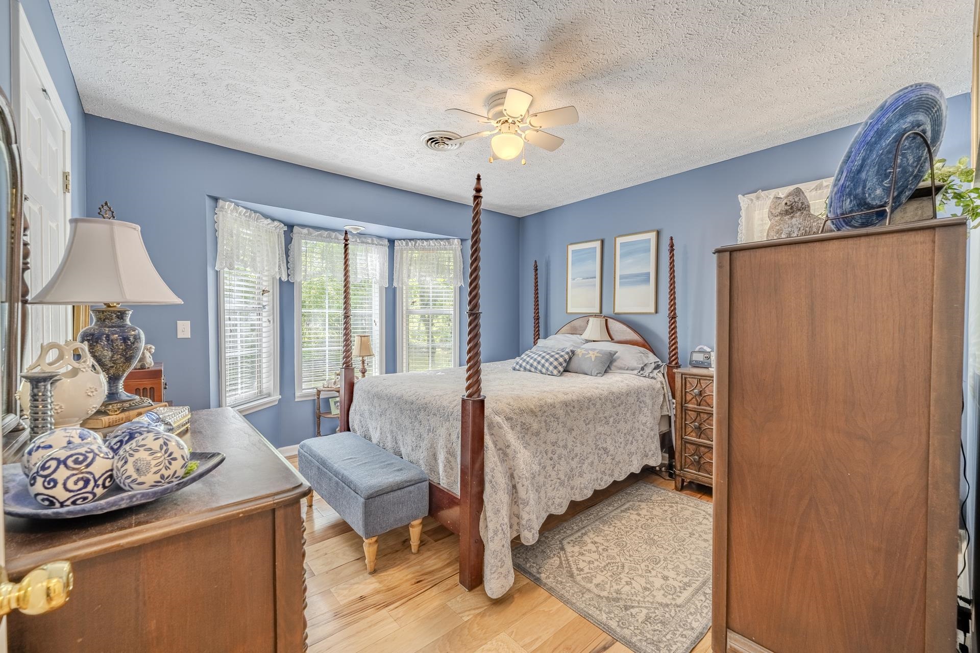 85 Cr 256 Road Iuka, MS 38852 - Photo 22 of 38 Bedroom featuring wood-finish flooring, a ceiling fan, and a prominent bay window with multiple panes