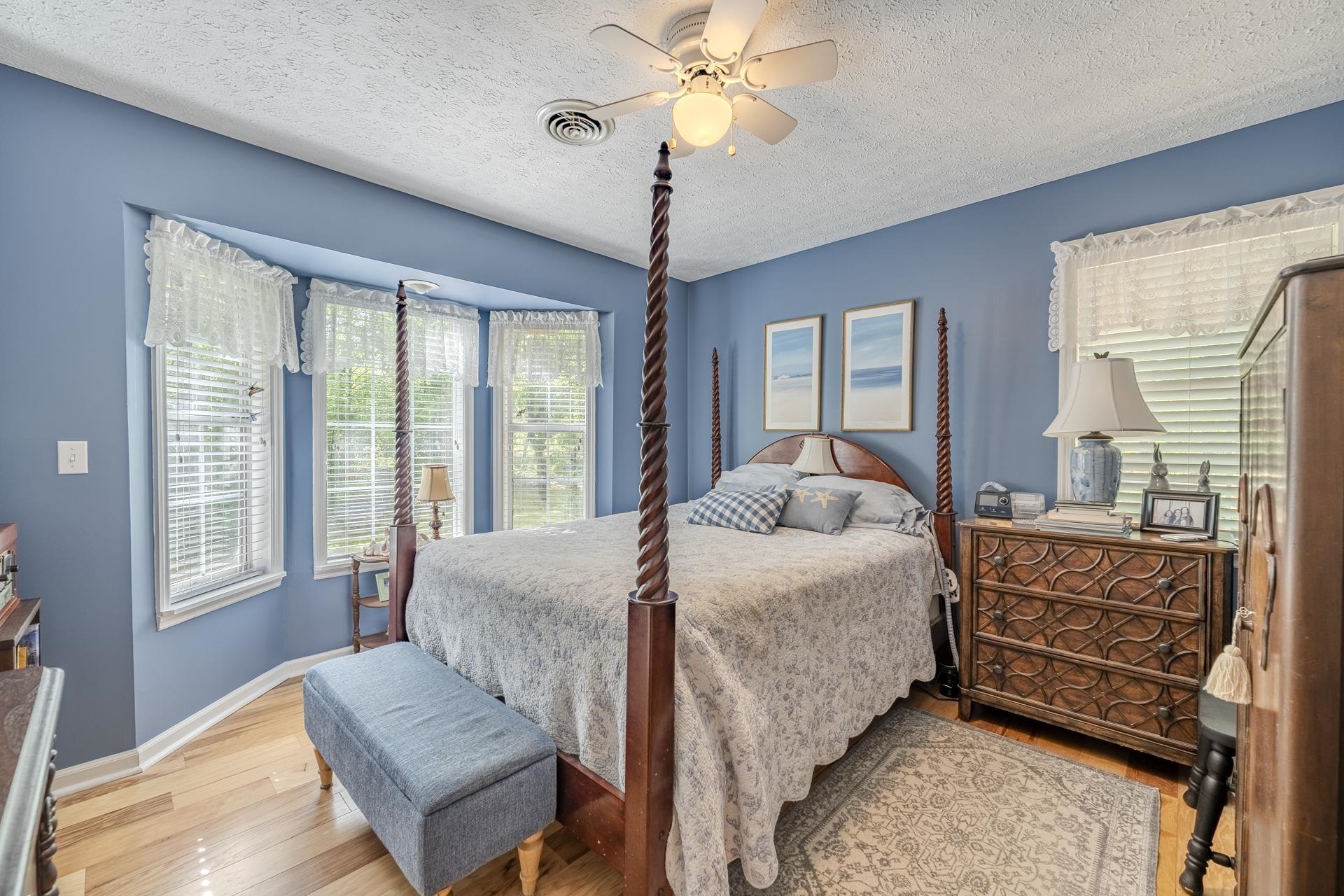 85 Cr 256 Road Iuka, MS 38852 - Photo 23 of 38 Bedroom featuring light wood-finish flooring, a bay window with three individual windows, a ceiling fan with integrated lighting, and light blue wall tones