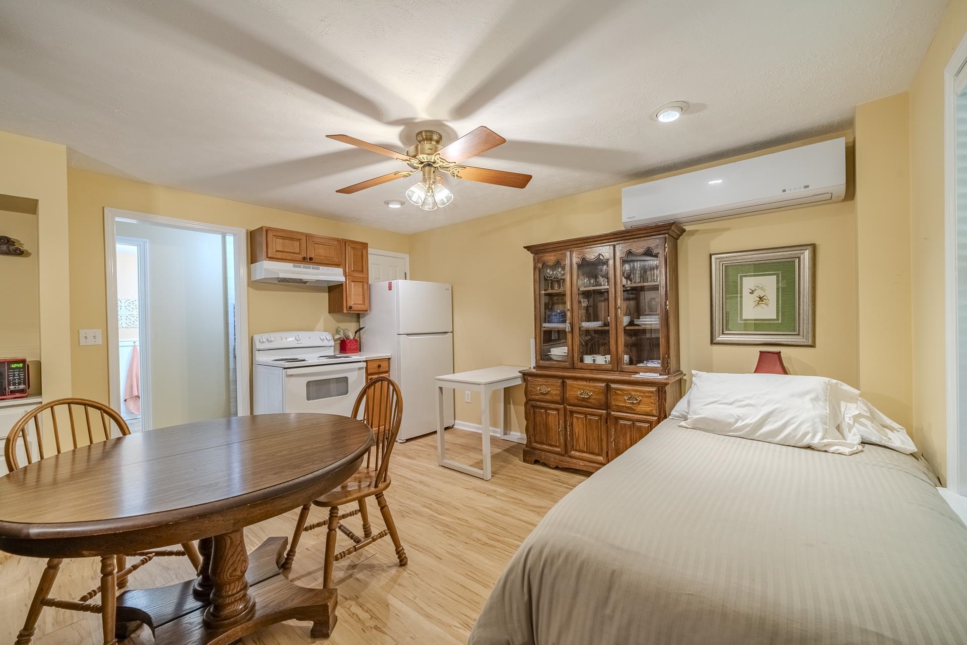 85 Cr 256 Road Iuka, MS 38852 - Photo 28 of 38 Open-concept living space featuring wood-finish flooring, a ceiling fan with integrated lighting, recessed lighting, a mini-split air conditioning unit, and a kitchen area with wood cabinetry and white appliances