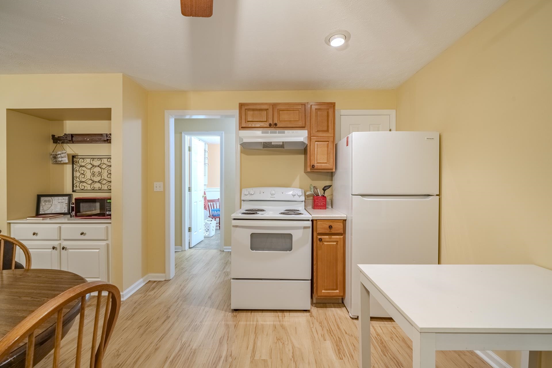 85 Cr 256 Road Iuka, MS 38852 - Photo 30 of 38 Kitchen area featuring wood-finish flooring, white appliances, and a built-in cabinet with a countertop