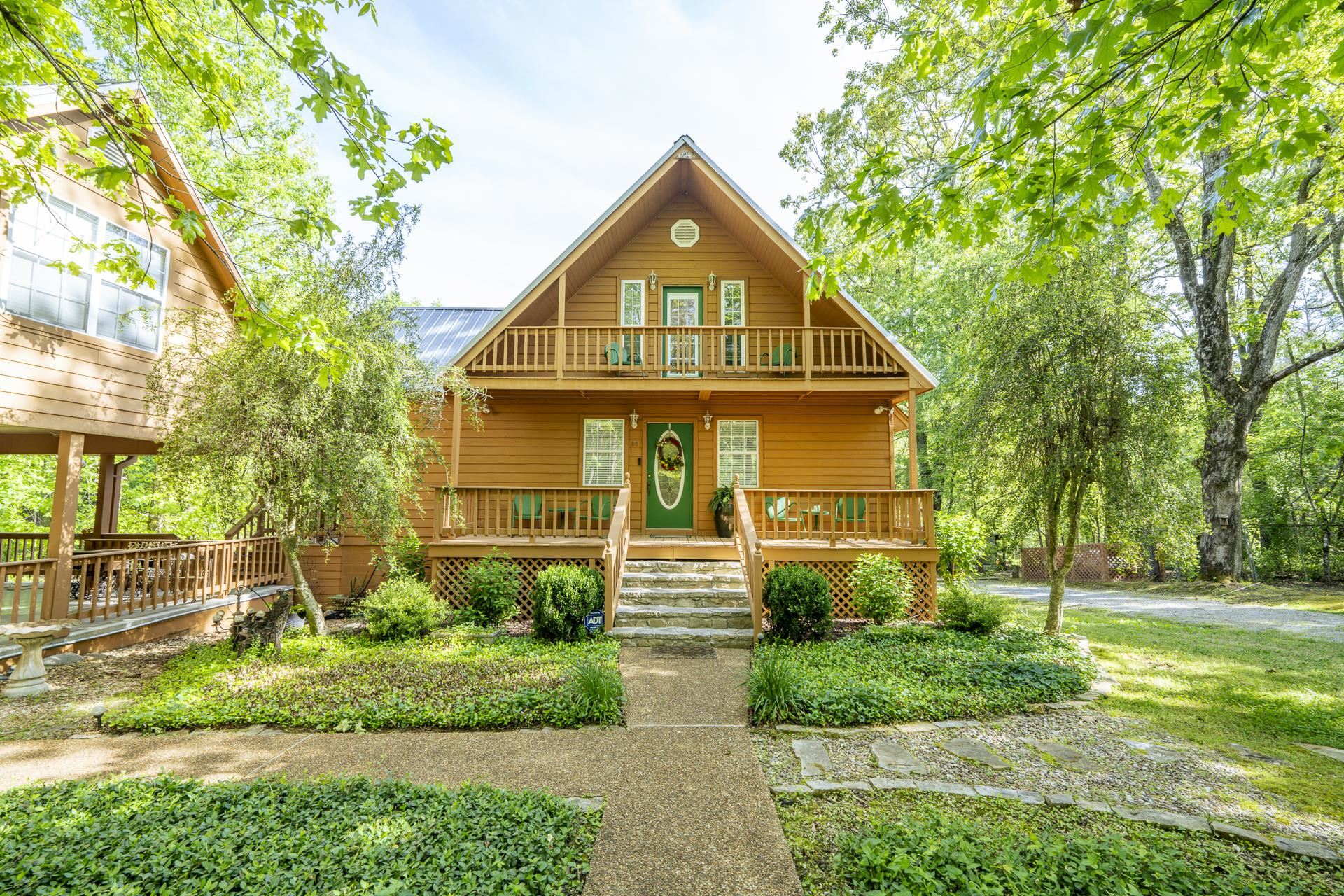 85 Cr 256 Road Iuka, MS 38852 - Photo 3 of 38 Wood-sided home featuring a front balcony, covered porch, and mature landscaping