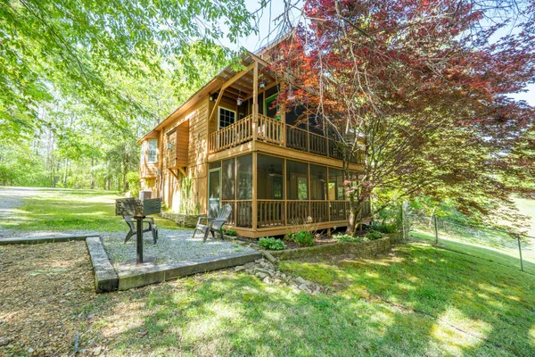 a view of a house with backyard and a tree