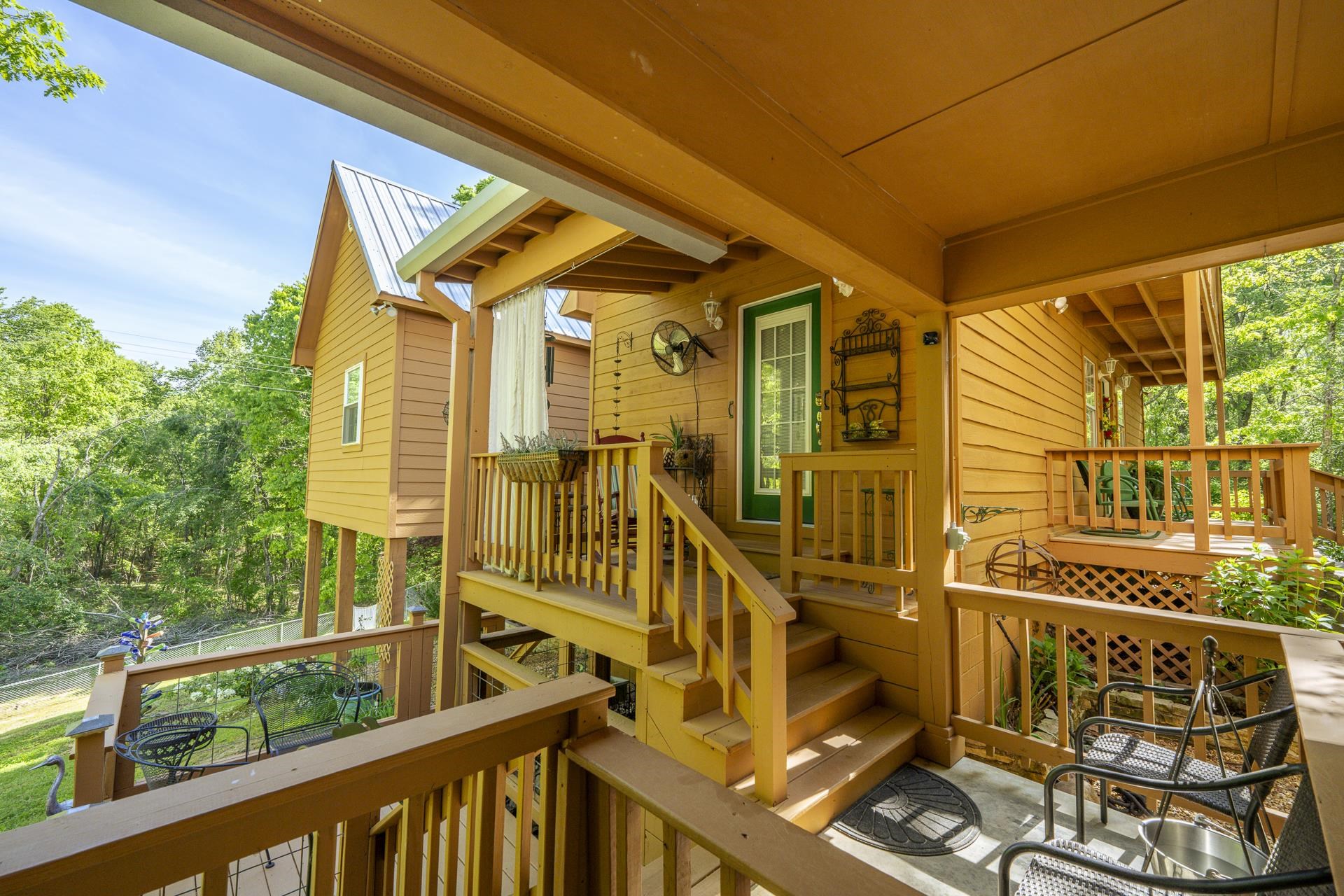 85 Cr 256 Road Iuka, MS 38852 - Photo 36 of 38 Multi-level outdoor living space featuring warm-toned wood construction, sturdy railings, a white metal roof, and a green painted exterior door