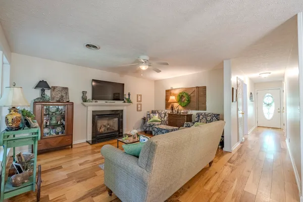 a living room with furniture a fireplace and a flat screen tv