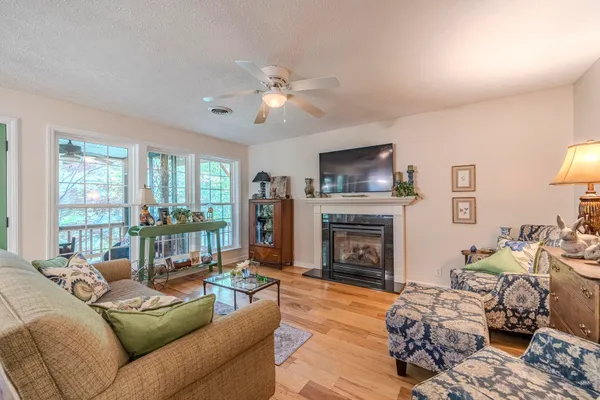 a living room with furniture large window and a fireplace