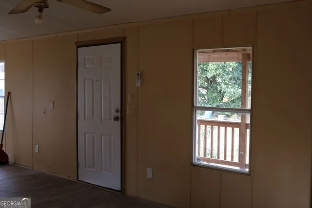 an empty room with wooden floor and a window