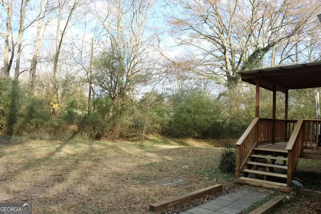 a view of a yard with wooden fence and a bench