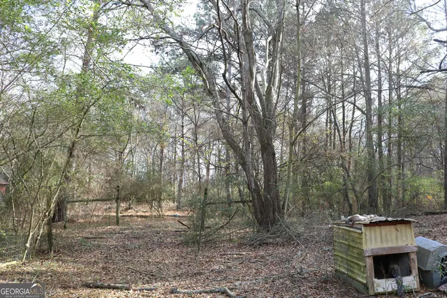 a view of an house with backyard space and trees