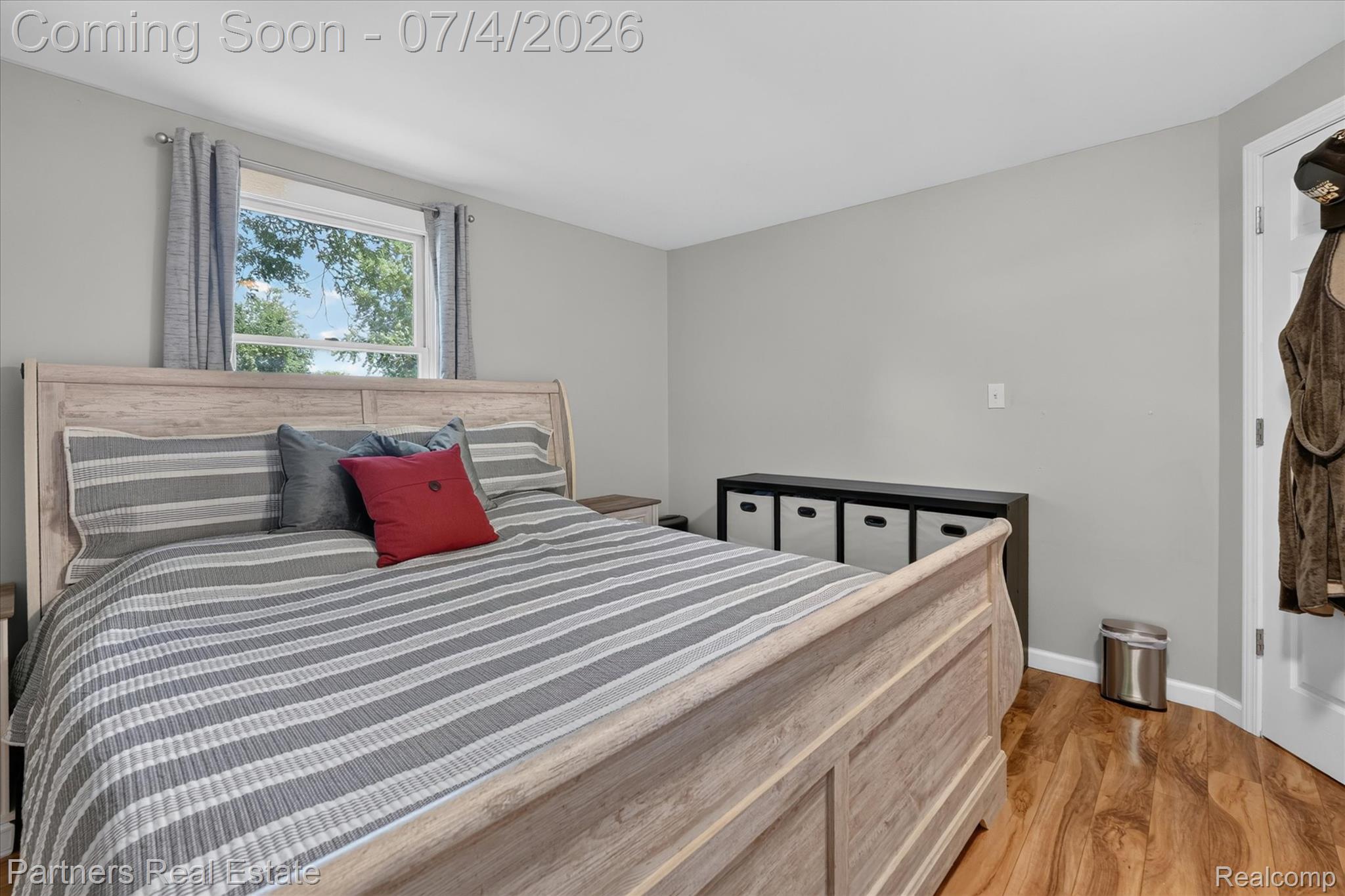 2500 Hubert Road Brighton, MI 48114 - Photo 28 of 53 Bedroom featuring wood-finish flooring, a window with curtains, and light gray wall paint