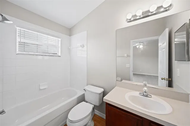 a bathroom with a sink a toilet a mirror a bathtub and shower