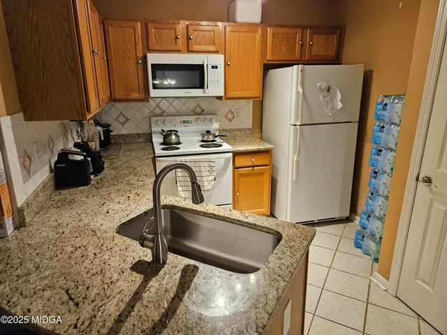 a kitchen with refrigerator a stove a washer and dryer