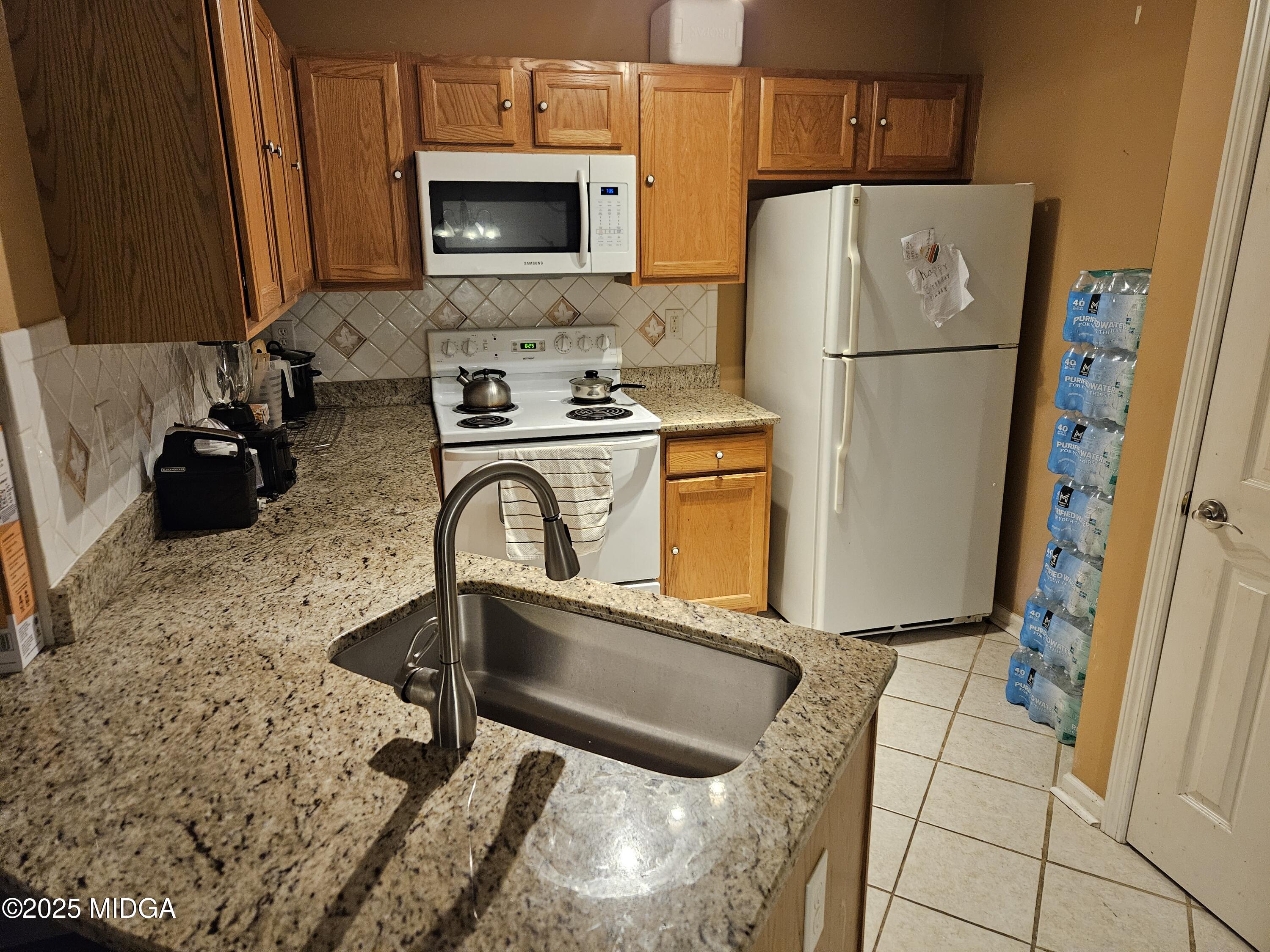 1500 Labonte Parkway McDonough, GA 30253 - Photo 4 of 15 a kitchen with refrigerator a stove a washer and dryer