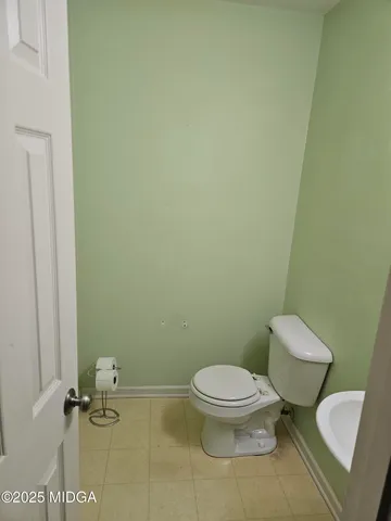 a white toilet sitting next to a white wall