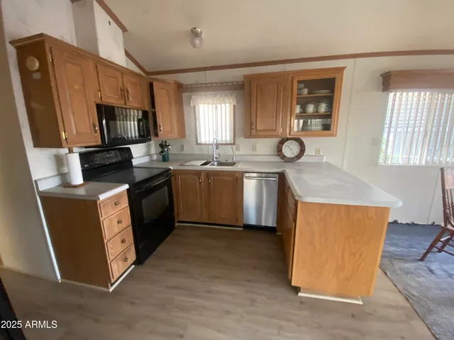 a kitchen with stainless steel appliances granite countertop wooden cabinets a sink a stove a refrigerator and dishwasher