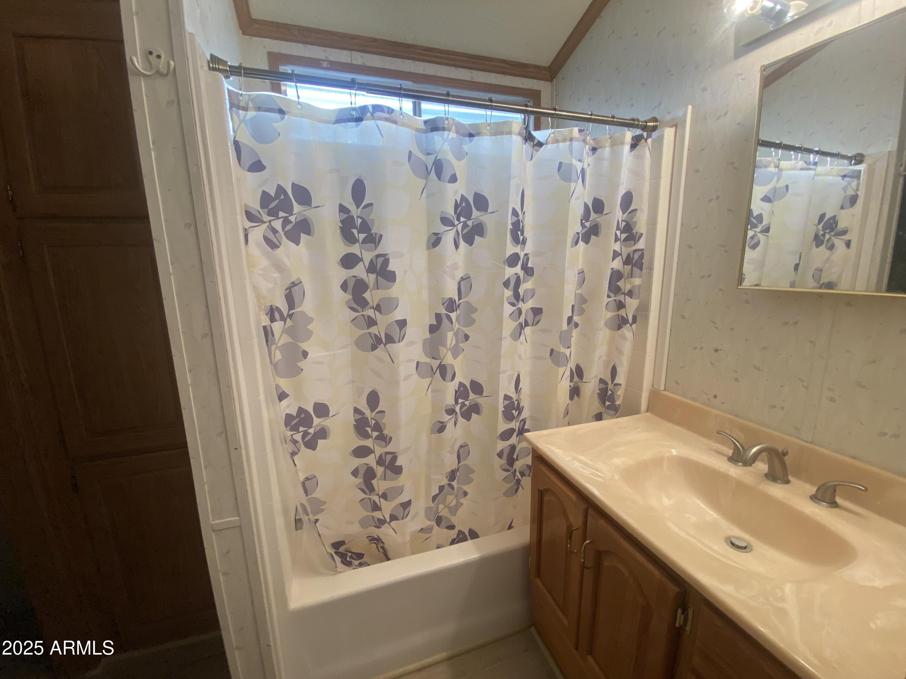 2137 West Erie Avenue, Unit 137 Apache Junction, AZ 85119 - Photo 14 of 36 a bathroom with a shower curtain and a sink