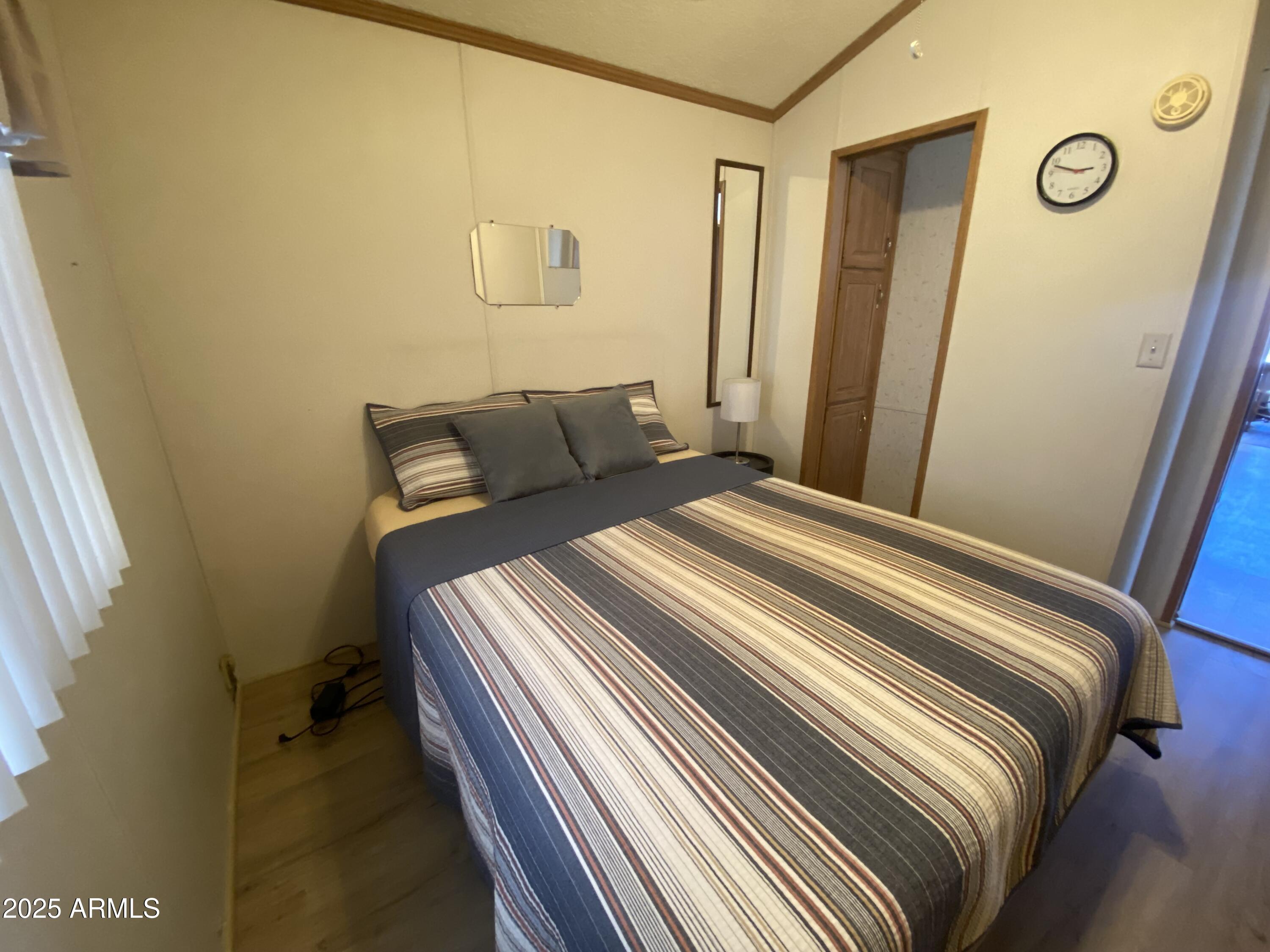 2137 West Erie Avenue, Unit 137 Apache Junction, AZ 85119 - Photo 19 of 36 a bedroom with a bed and a mirror