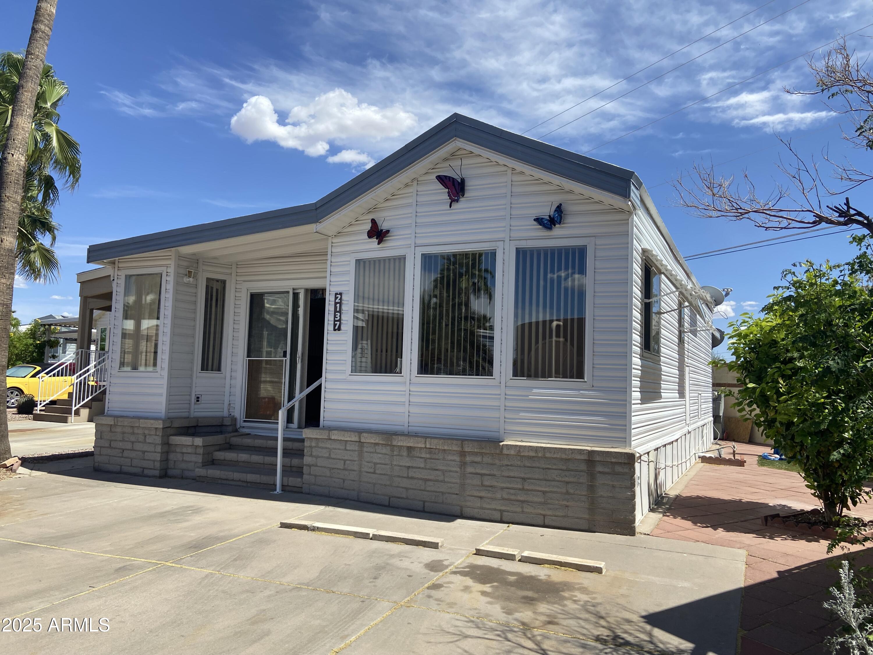 2137 West Erie Avenue, Unit 137 Apache Junction, AZ 85119 - Photo 27 of 36 a front view of a house with a yard