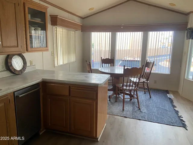 a kitchen with kitchen island granite countertop a table chairs sink and cabinets