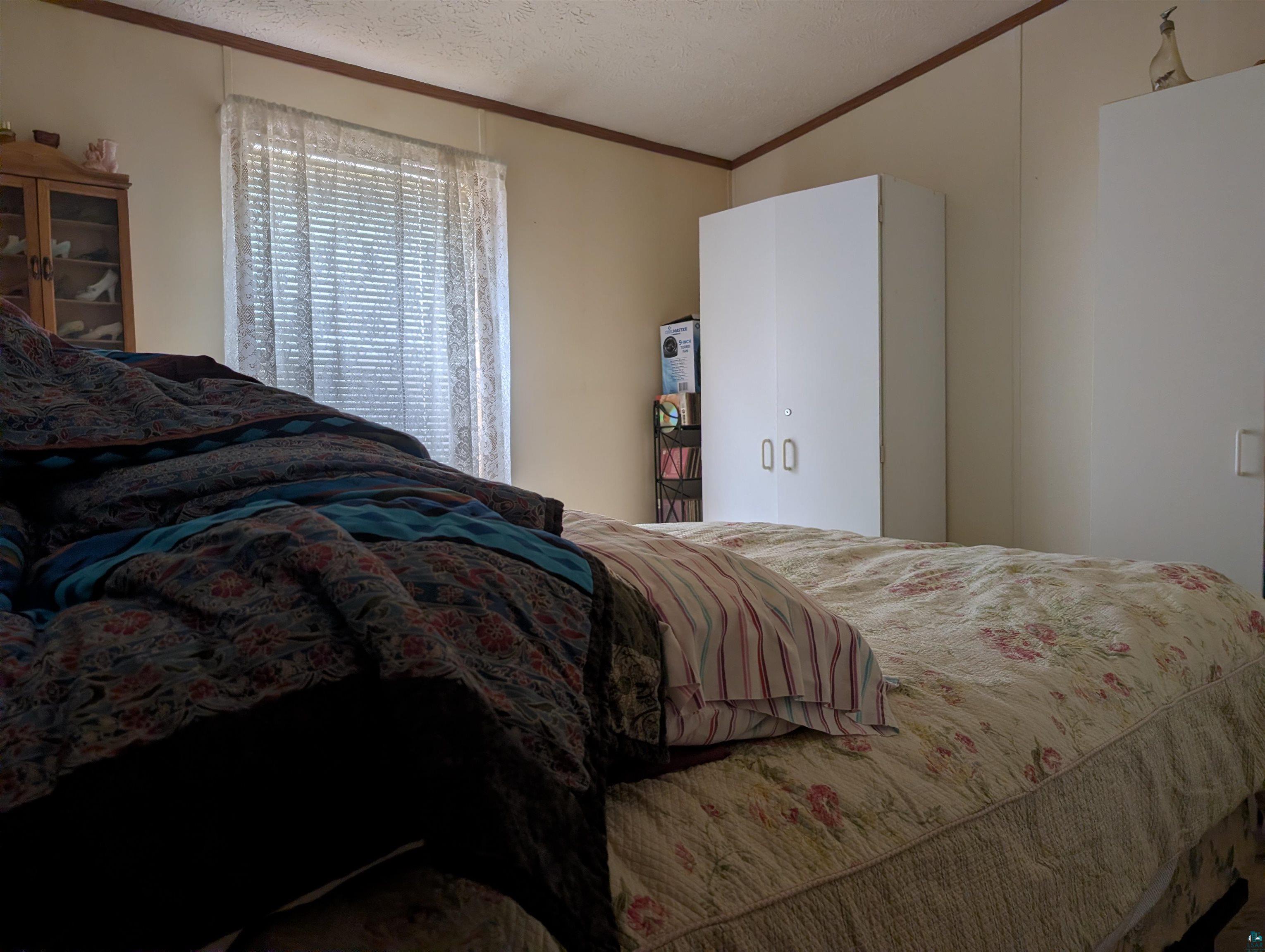 54700 Cudworth Avenue Grand View, WI 54839 - Photo 18 of 21 Bedroom featuring crown molding and a textured ceiling