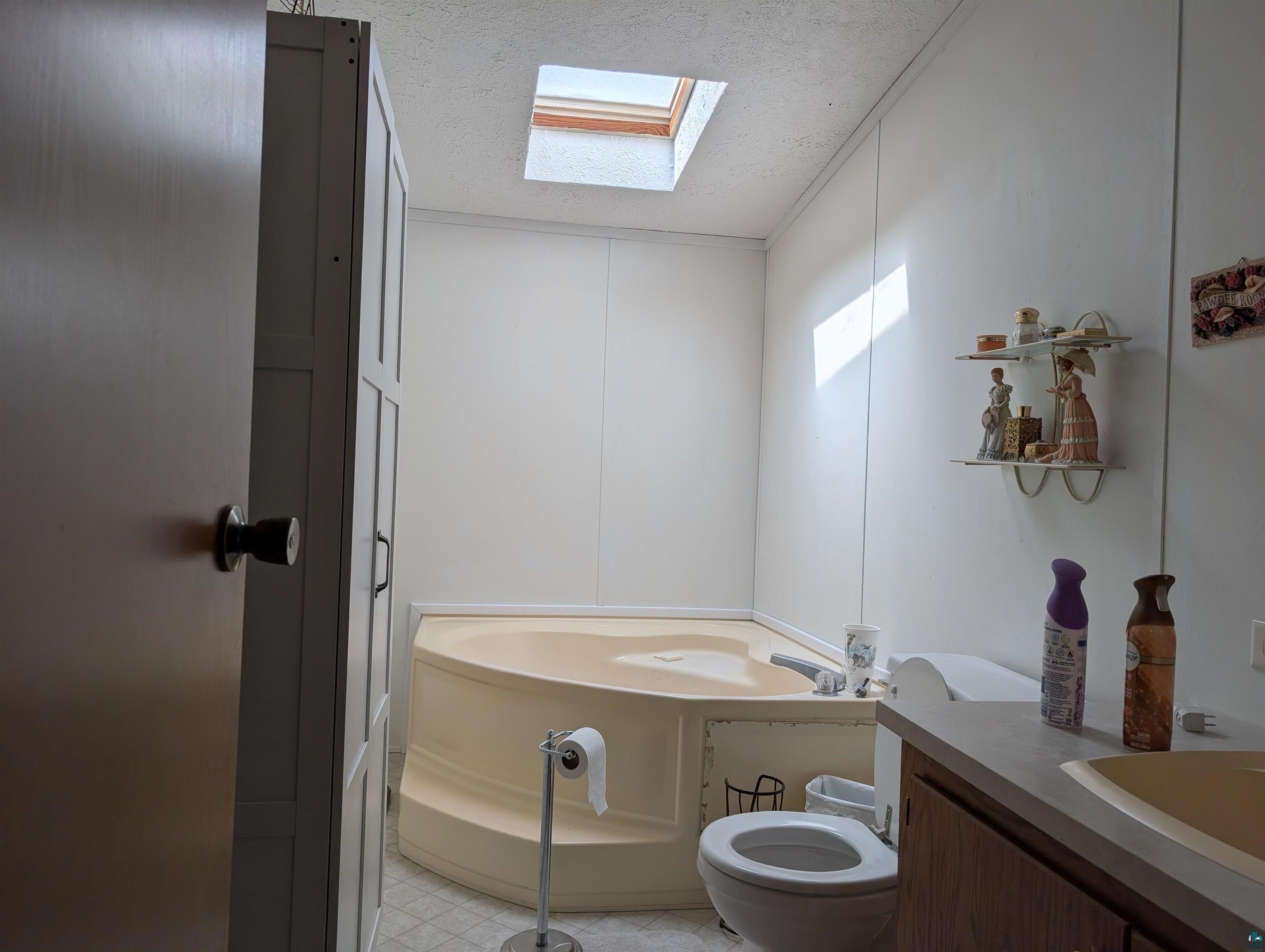 54700 Cudworth Avenue Grand View, WI 54839 - Photo 20 of 21 Bathroom with a bath, a textured ceiling, a skylight, and vanity