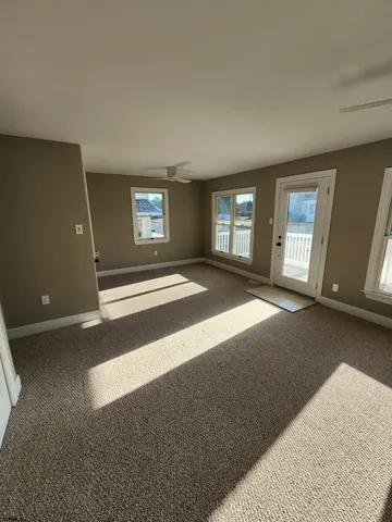 a view of an empty room with a window and fireplace