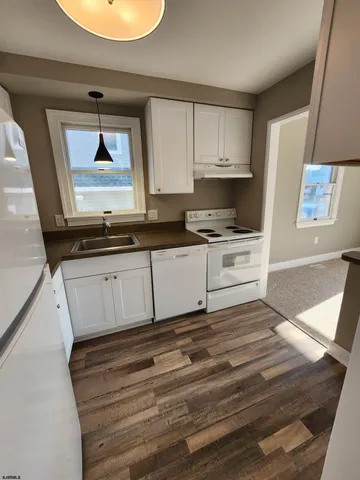 a kitchen with white cabinets and window