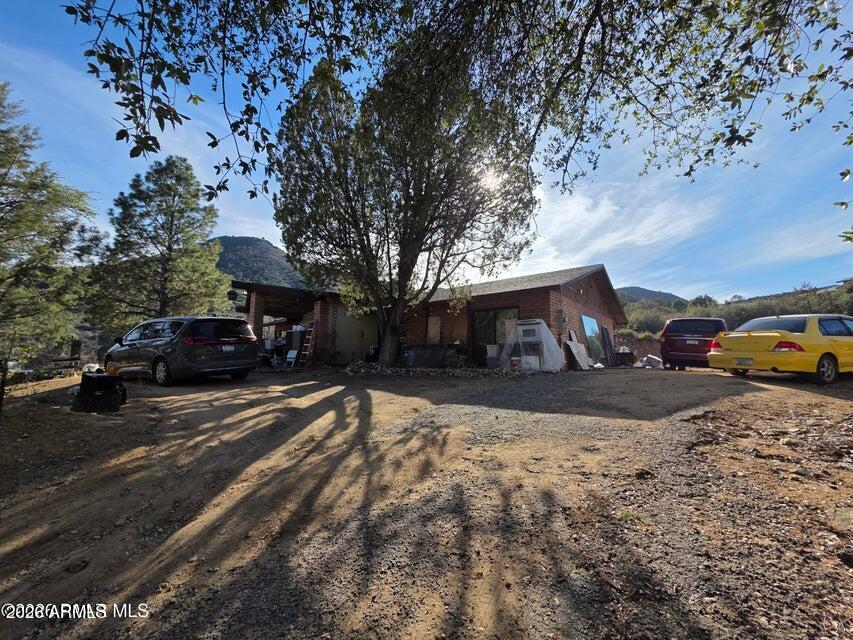 10515 West Cherry Creek Road Dewey, AZ 86327 - Photo 1 of 6 a front view of a house with cars parked on road