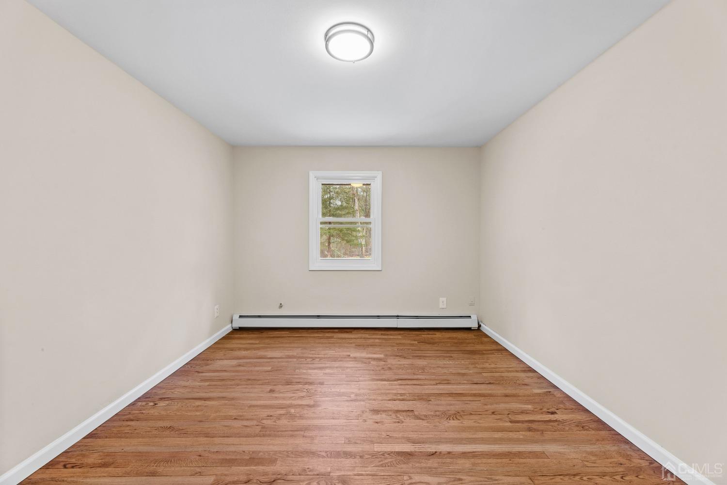 145 Texas Road Old Bridge, NJ 08857 - Photo 10 of 35 an empty room with wooden floor and windows