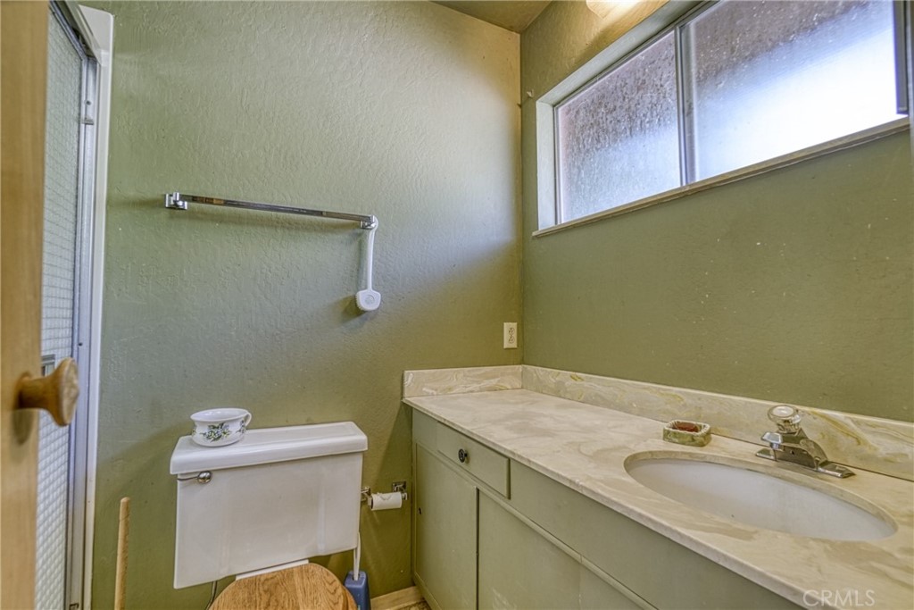 7783 Cora Drive Lucerne, CA 95458 - Photo 22 of 41 a bathroom with a granite countertop sink and a toilet