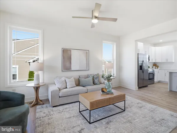 a living room with furniture kitchen view and a window