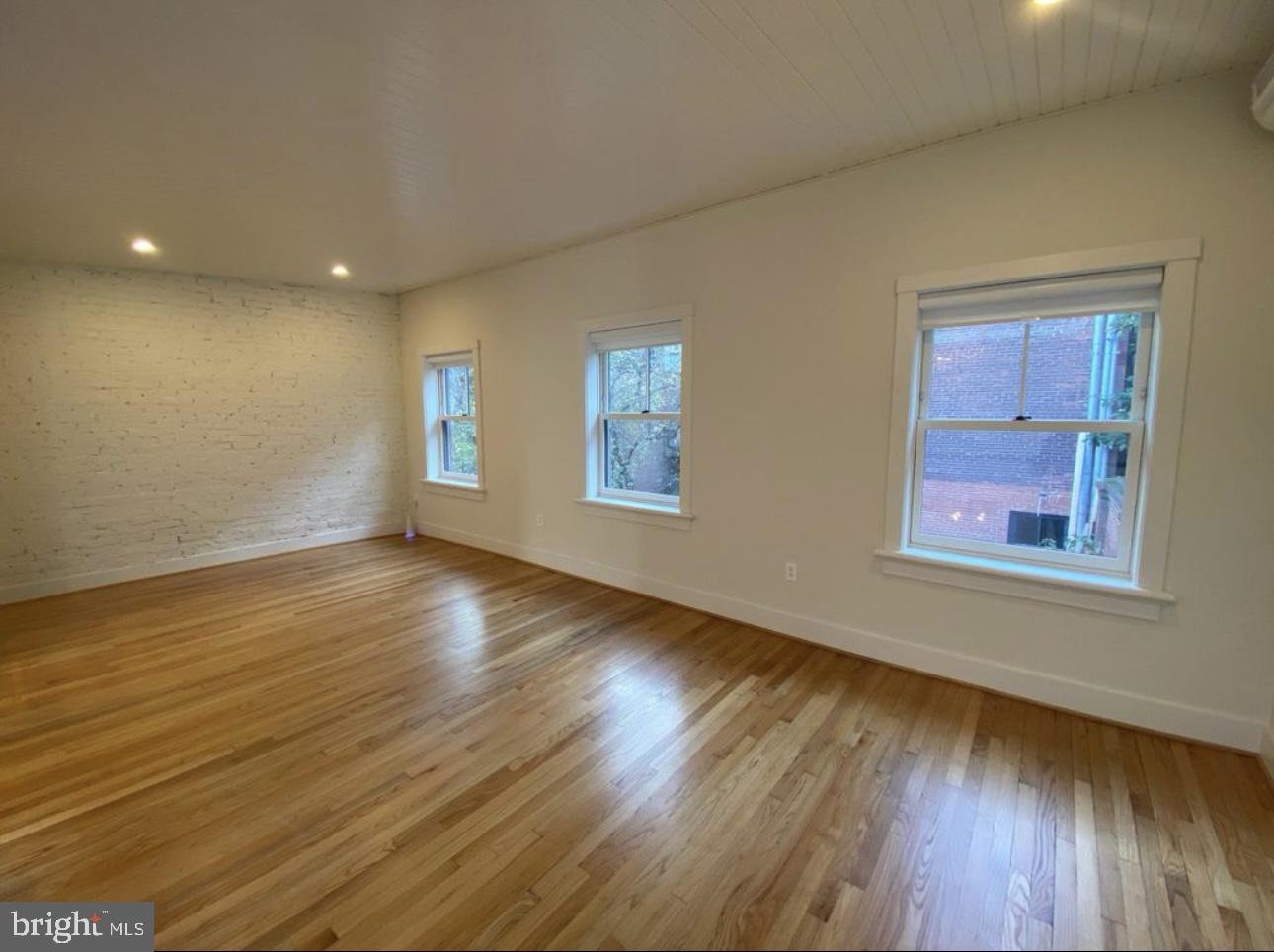 19 Branch Lane East Baltimore, MD 21202 - Photo 5 of 13 a view of an empty room with wooden floor and a window
