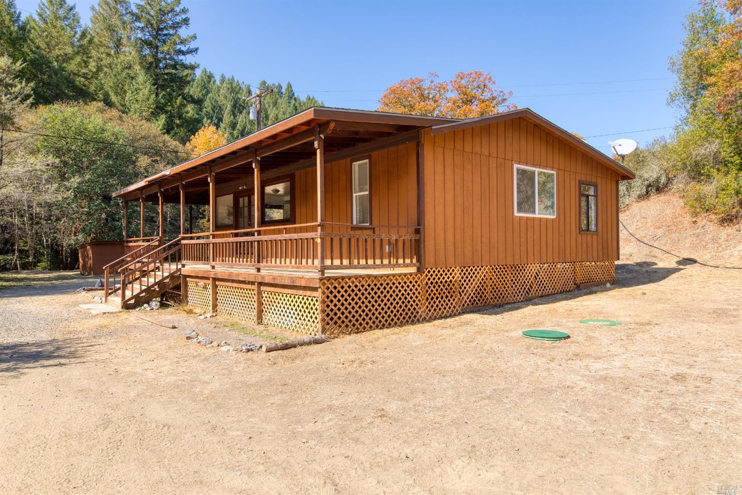 7900 Hearst Road Willits, CA 95490 - Photo 1 of 1 a front view of a house with a wooden fence