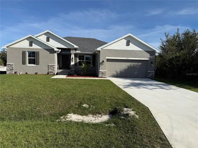 a front view of a house with a yard and garage