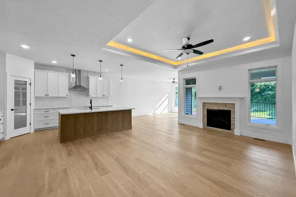 a large kitchen with a fireplace cabinets and a wooden floor