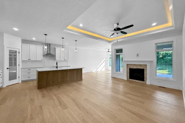 a large kitchen with a fireplace cabinets and a wooden floor