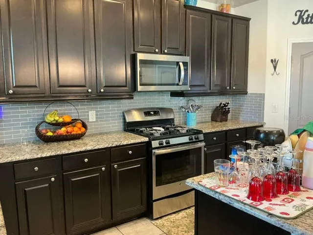 a kitchen with stainless steel appliances granite countertop a sink stove and cabinets