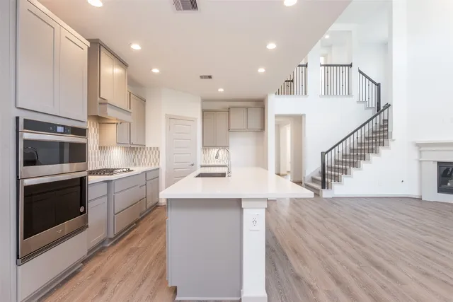 a kitchen with stainless steel appliances kitchen island granite countertop a stove a sink and a refrigerator
