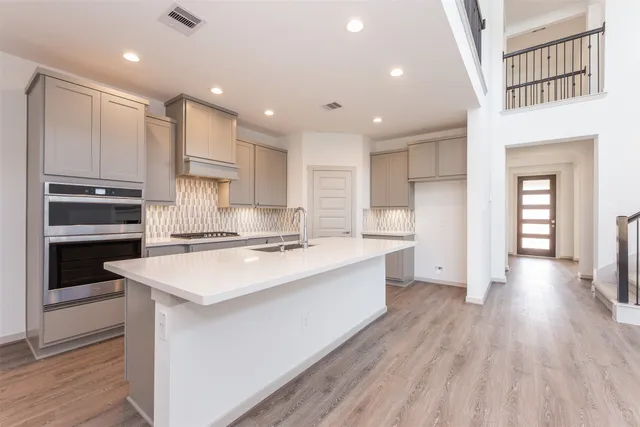 a large kitchen with kitchen island a sink stainless steel appliances and cabinets