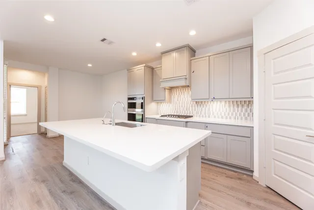 a kitchen with kitchen island a stove a sink and a refrigerator