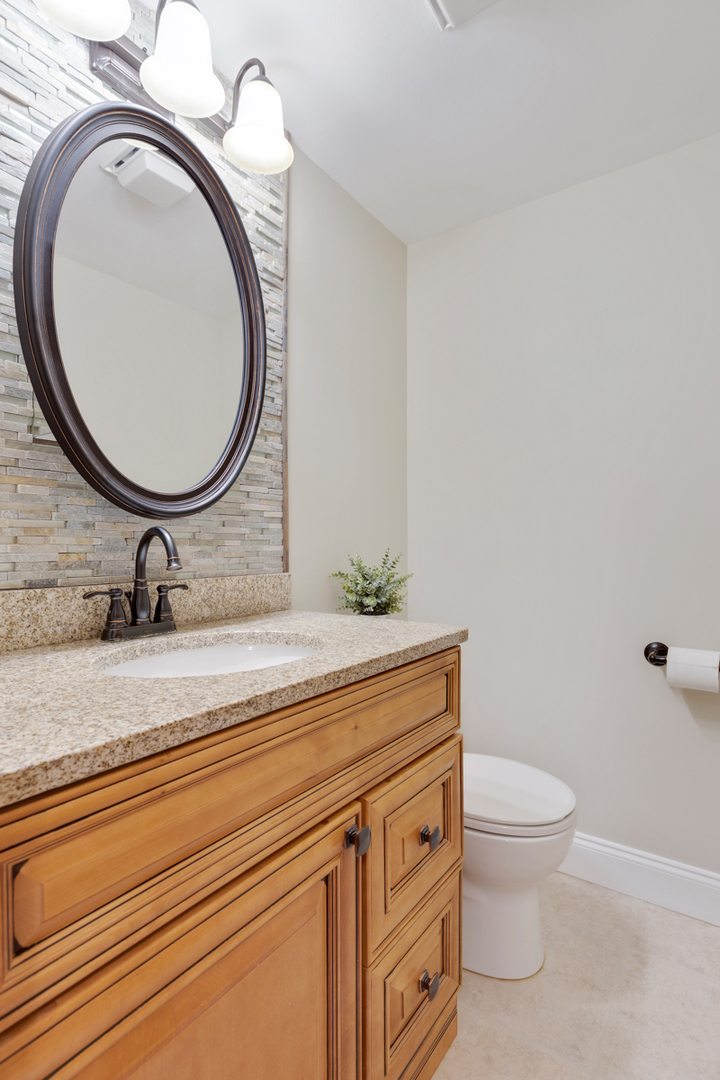 102 Harding Avenue Fox River Grove, IL 60021 - Photo 13 of 29 a bathroom with a granite countertop toilet a sink and a mirror