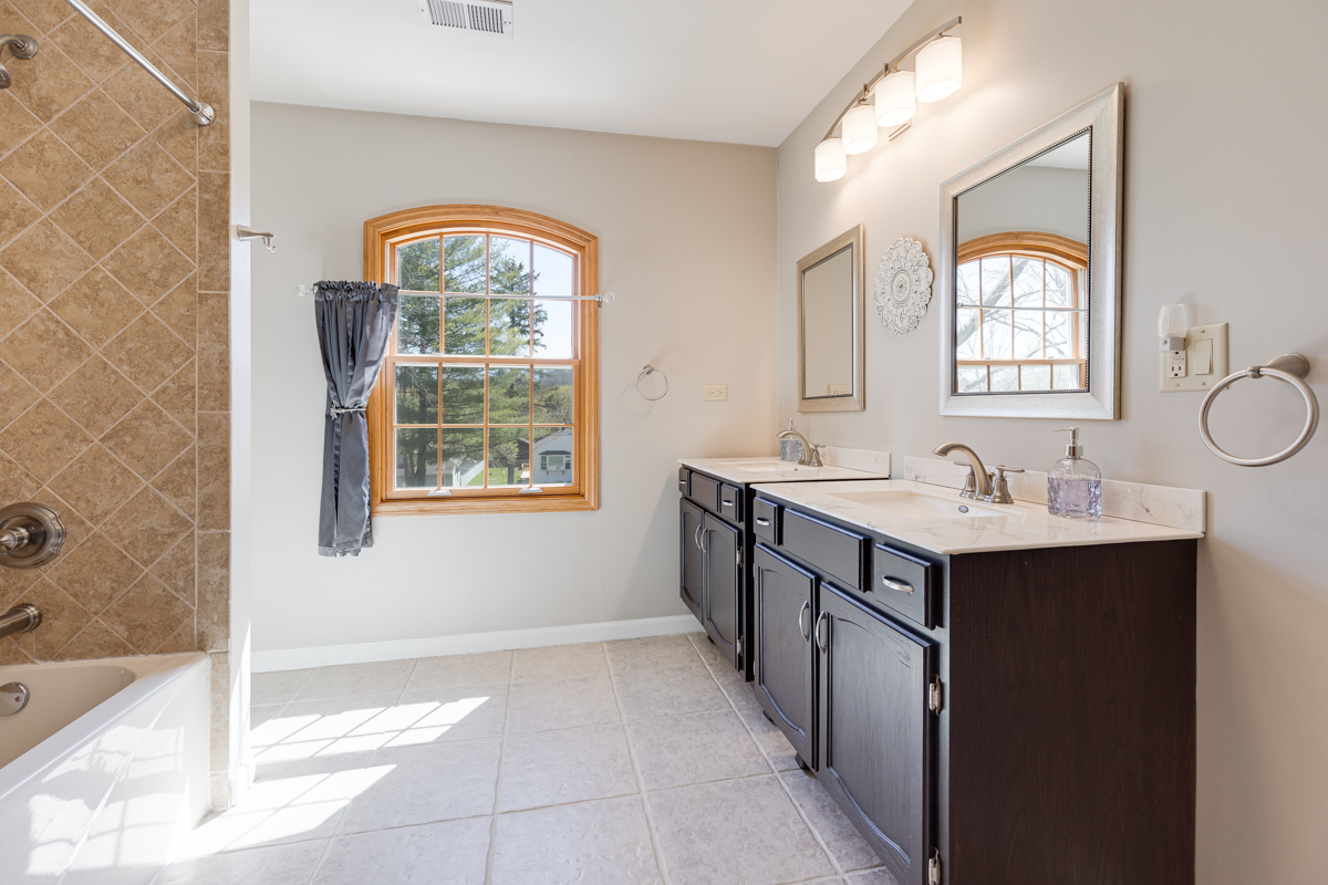 102 Harding Avenue Fox River Grove, IL 60021 - Photo 24 of 29 a bathroom with a double vanity sink a mirror and a bathtub