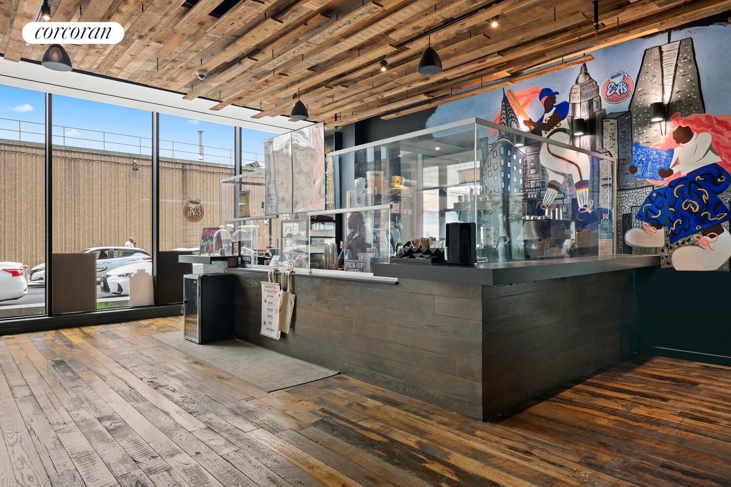 54 Noll Street, Unit 819 Brooklyn, NY 11206 - Photo 25 of 26 a kitchen with stainless steel appliances granite countertop a refrigerator a stove and a sink with wooden floor