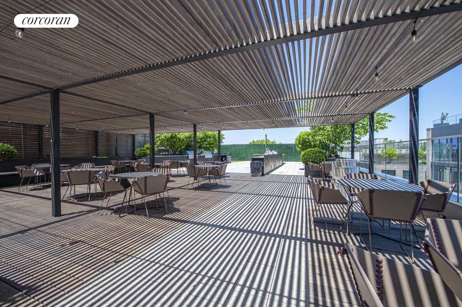 54 Noll Street, Unit 819 Brooklyn, NY 11206 - Photo 9 of 26 a view of a patio with dining table and chairs under an umbrella with a patio