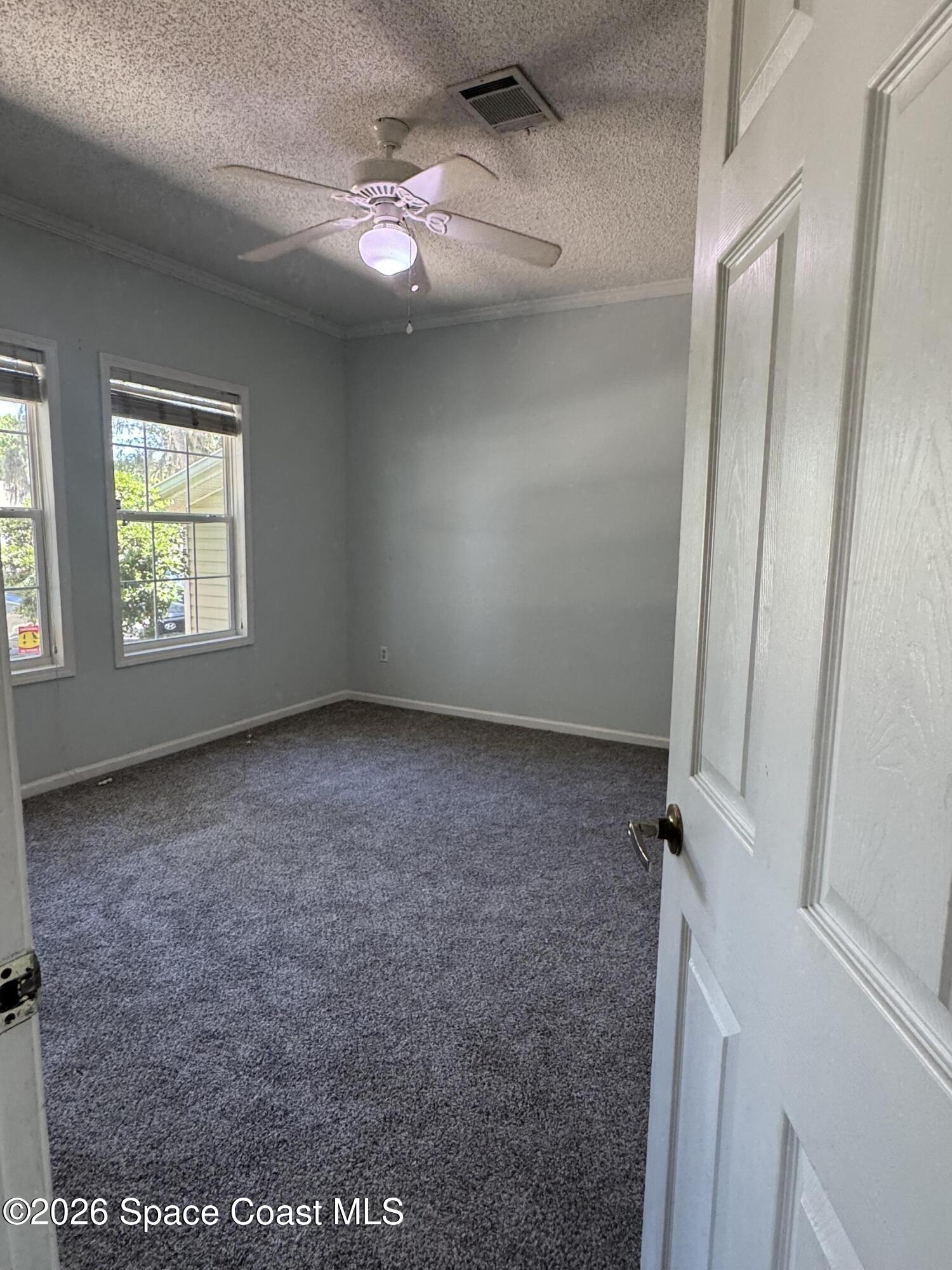 1130 Grapefruit Road Southeast Palm Bay, FL 32909 - Photo 7 of 14 an empty room with windows and closet