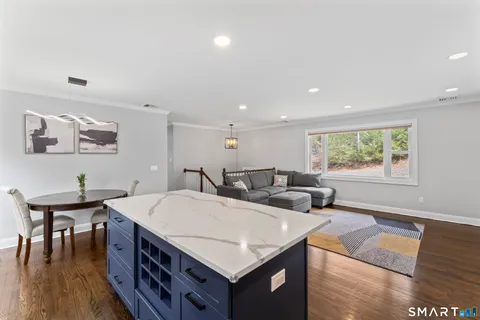 a living room with stainless steel appliances furniture a window and a kitchen view