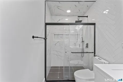 a bathroom with a shower a toilet and a sink