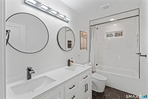 a bathroom with a sink a toilet and a mirror