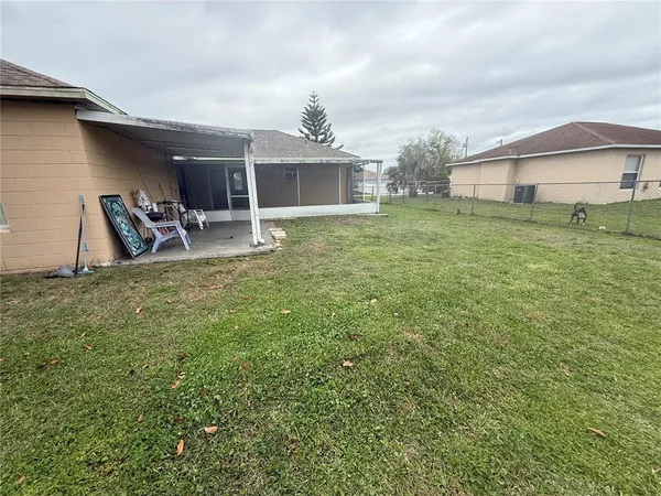 a backyard of a house with table and chairs
