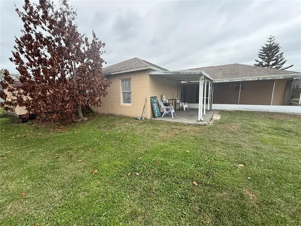 a backyard of a house with table and chairs